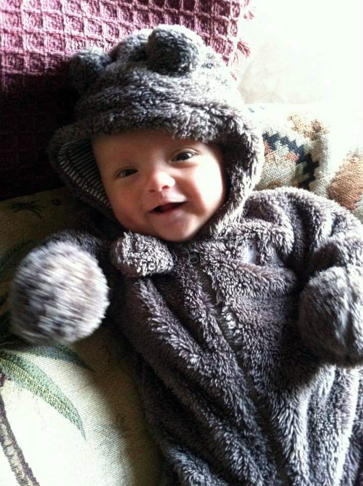 Wiley Muir smiles as he wears a bear onesie.