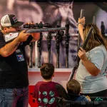 A family with young children views rifles during the National Rifle Association annual convention.
