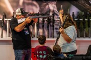 A family with young children views rifles during the National Rifle Association annual convention.