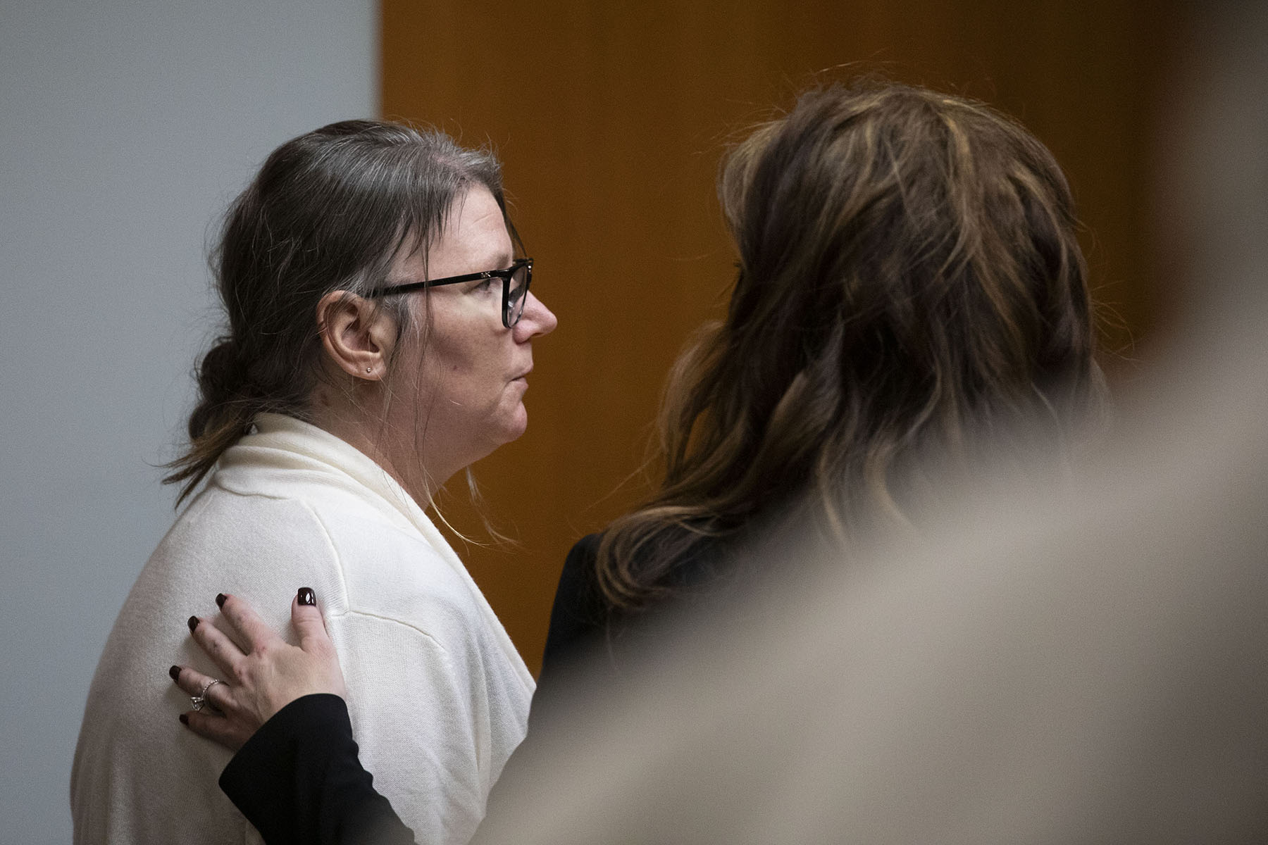 Jennifer Crumbley's attorney places her hand on Crumbley's shoulder to comfort her in Oakland County Circuit Court.
