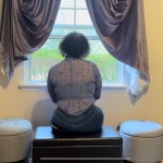 Jae Cancel sits at the window inside a Tallahassee, Florida, transgender safe house.