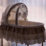 Photo of a crib with plush lambs hanging from a mobile.