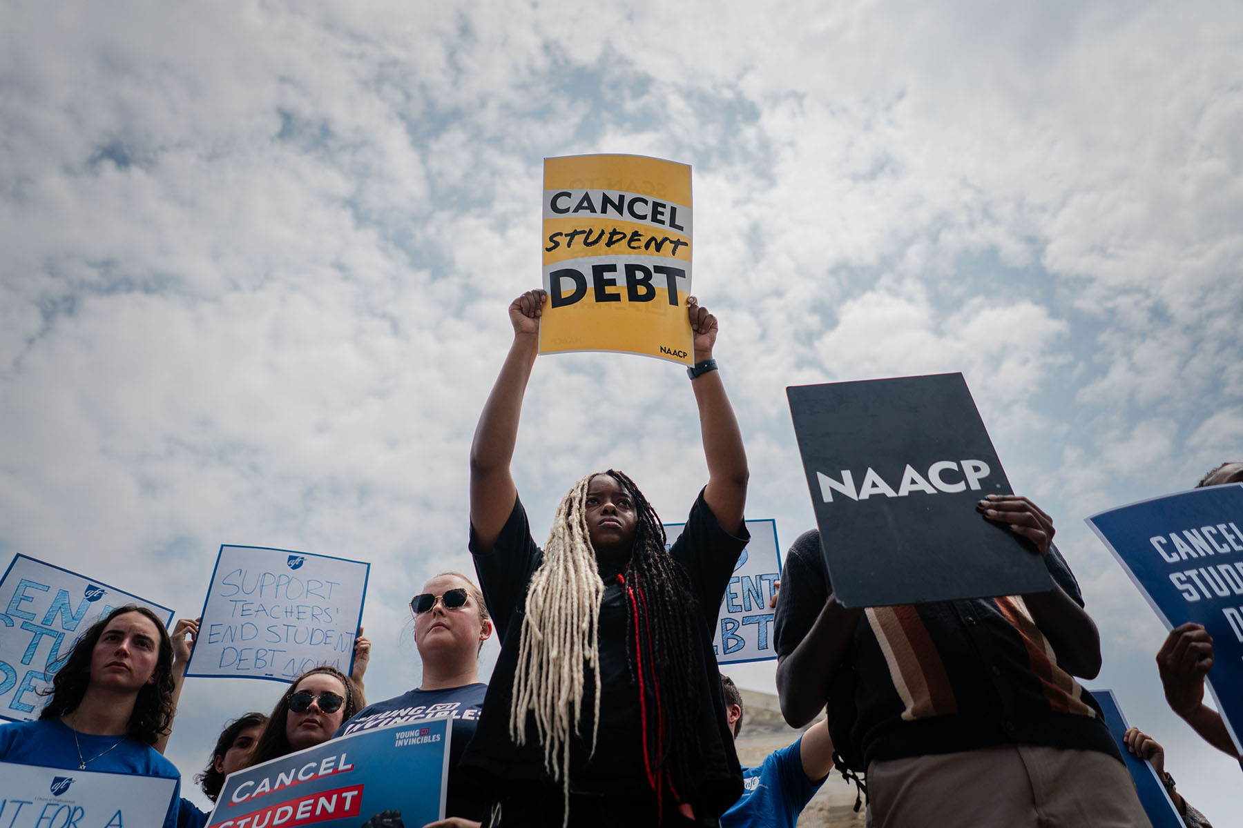 Protesters hold "Cancel Student Debt" sign outside of the Supreme Court of the United States after the nation's high court stuck down President Biden's student debt relief program.