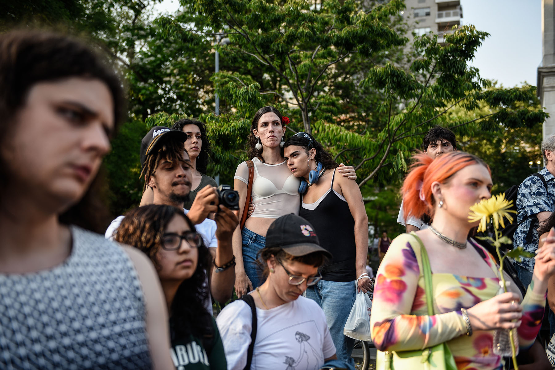 Two people are seen hugging as others listen during a weekly gathering in support of trans people.
