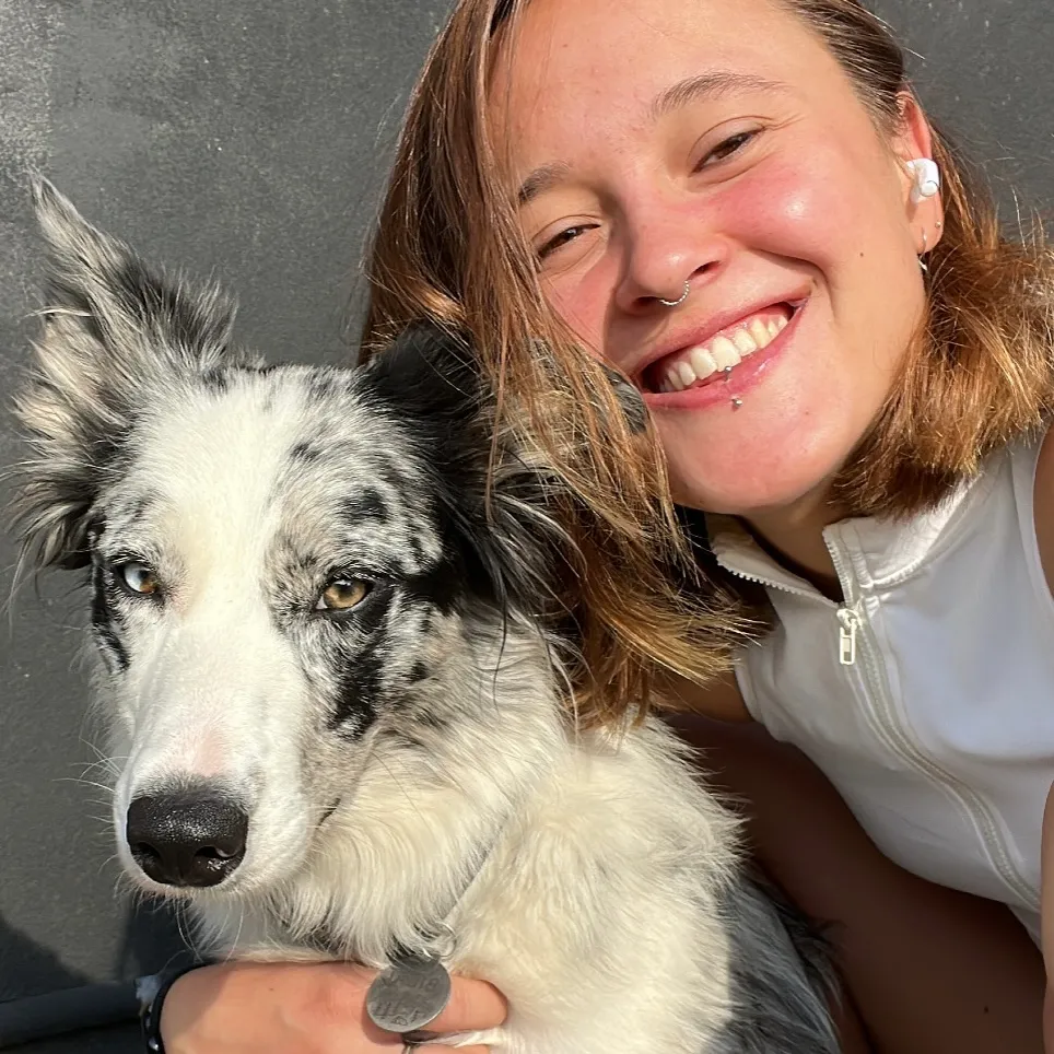 Oihana Larraiotz poses for a photo with a dog.
