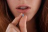 Close-up of an unidentified person as she holds a contraceptive pill.