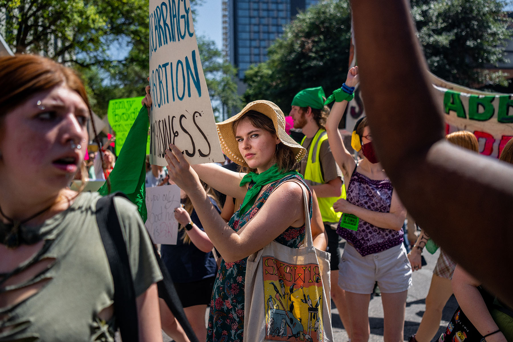A woman holding a sign looks straight into the camera as abortion rights activists and supporters march outside of the Austin Convention Center, in May 2022.