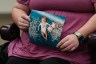 close-up photo of a seated woman holding a photograph of her baby, who was conceived through IVF