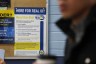 A poster for Real ID is seen on a cork board at a DMV.