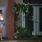 A woman holds a baby as she watches rising flood waters during Hurricane Florence.