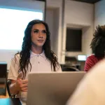 A trans woman attends a staff meeting at the office.