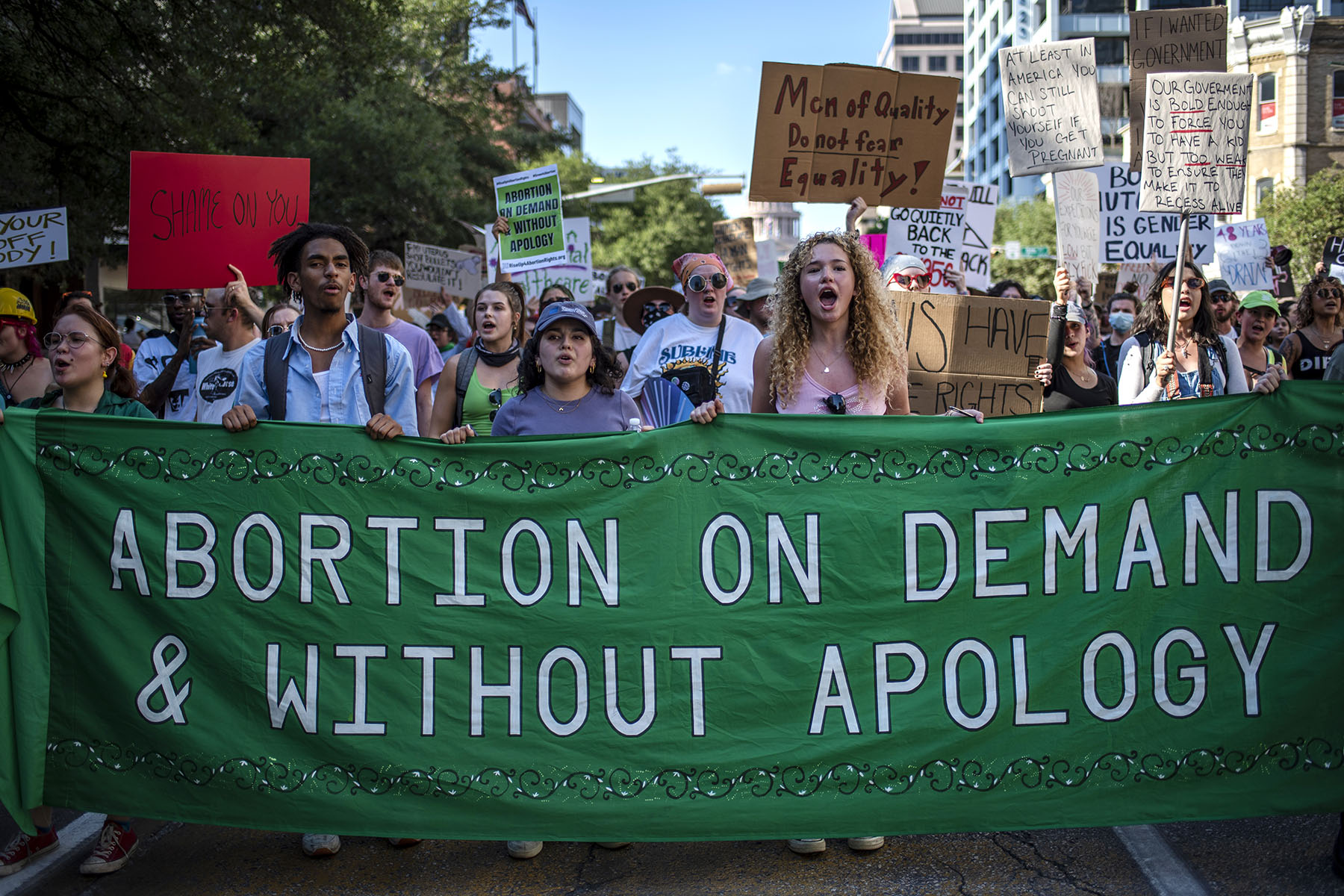 Protesters march while holding signs during an abortion-rights rally in Austin, Texas.