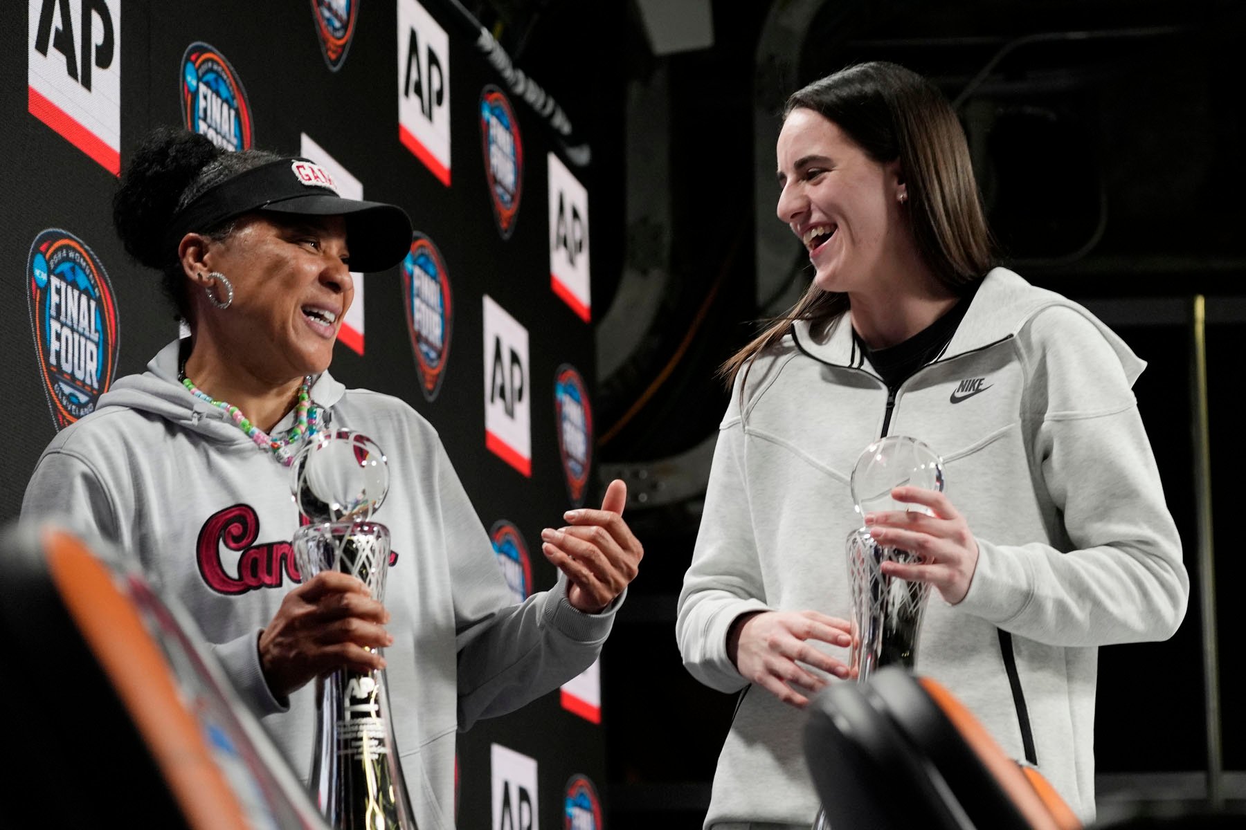 South Carolina head coach Dawn Staley and Iowa's Caitlin Clark stand together on stage during a news conference announcing the AP NCAA Women's Coach and Player of the Year.
