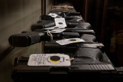 Semi-automatic firearms are displayed for sale on a shelf at a gun store.