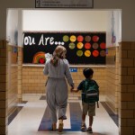 A teachers leads her student to English class at an elementary school.