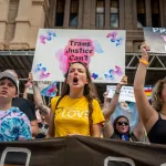 People protest in front of the Texas State Capitol during a Queer March demonstration.
