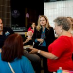 Debbie-Mucarsel-Powell listens as people ask questions into a microphone at a coffee shop during a meet and greet.