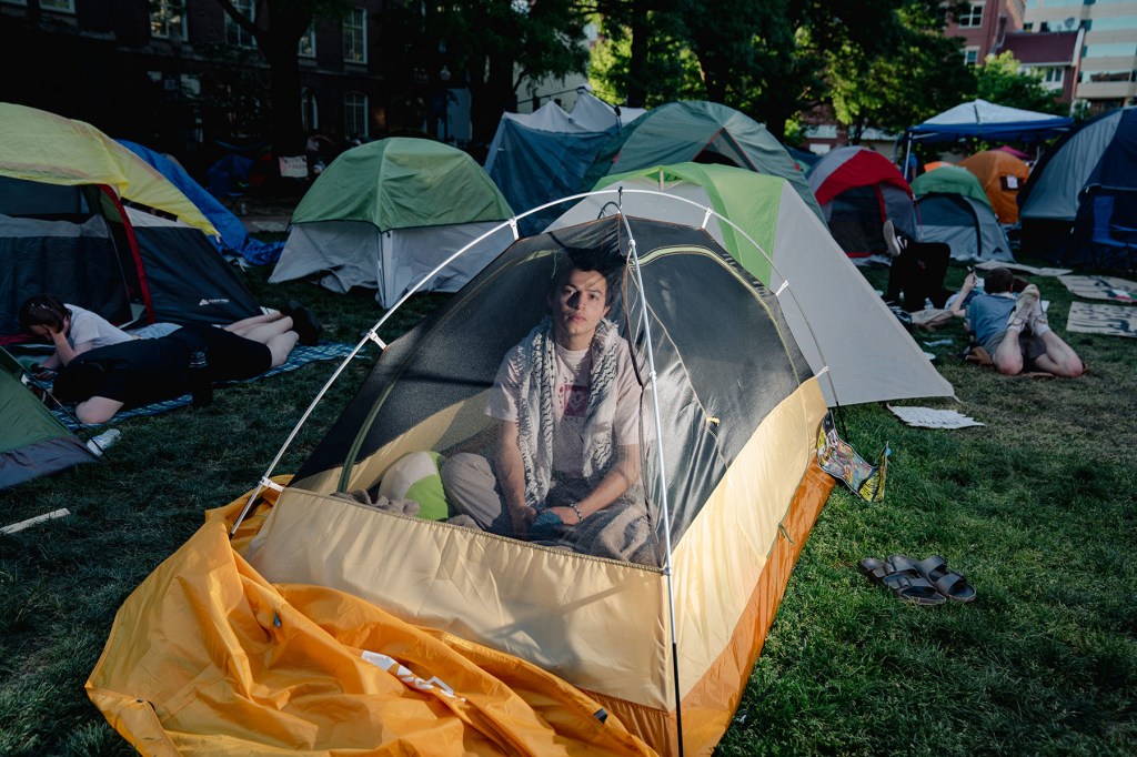 Juan looks out from inside his tent at the GWU encampment.