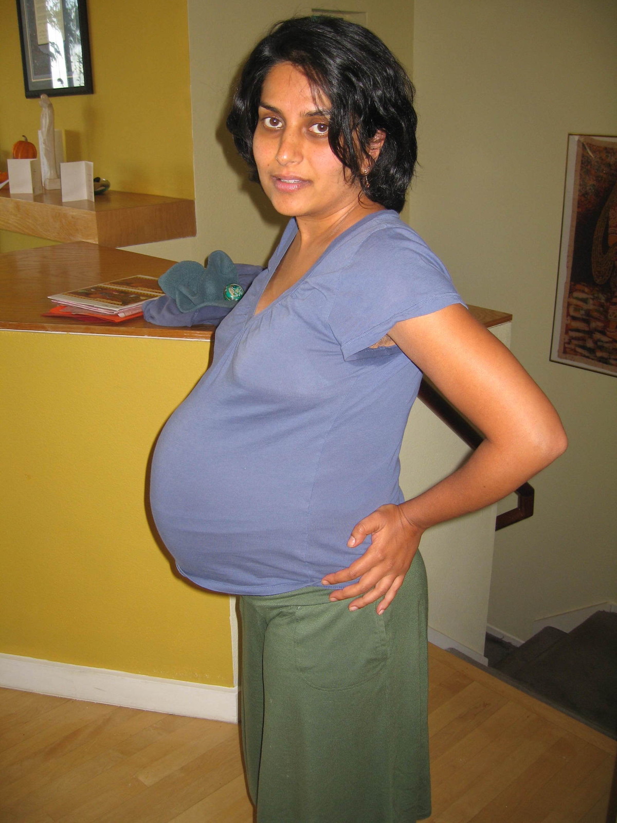 A pregnant woman poses for a photo.