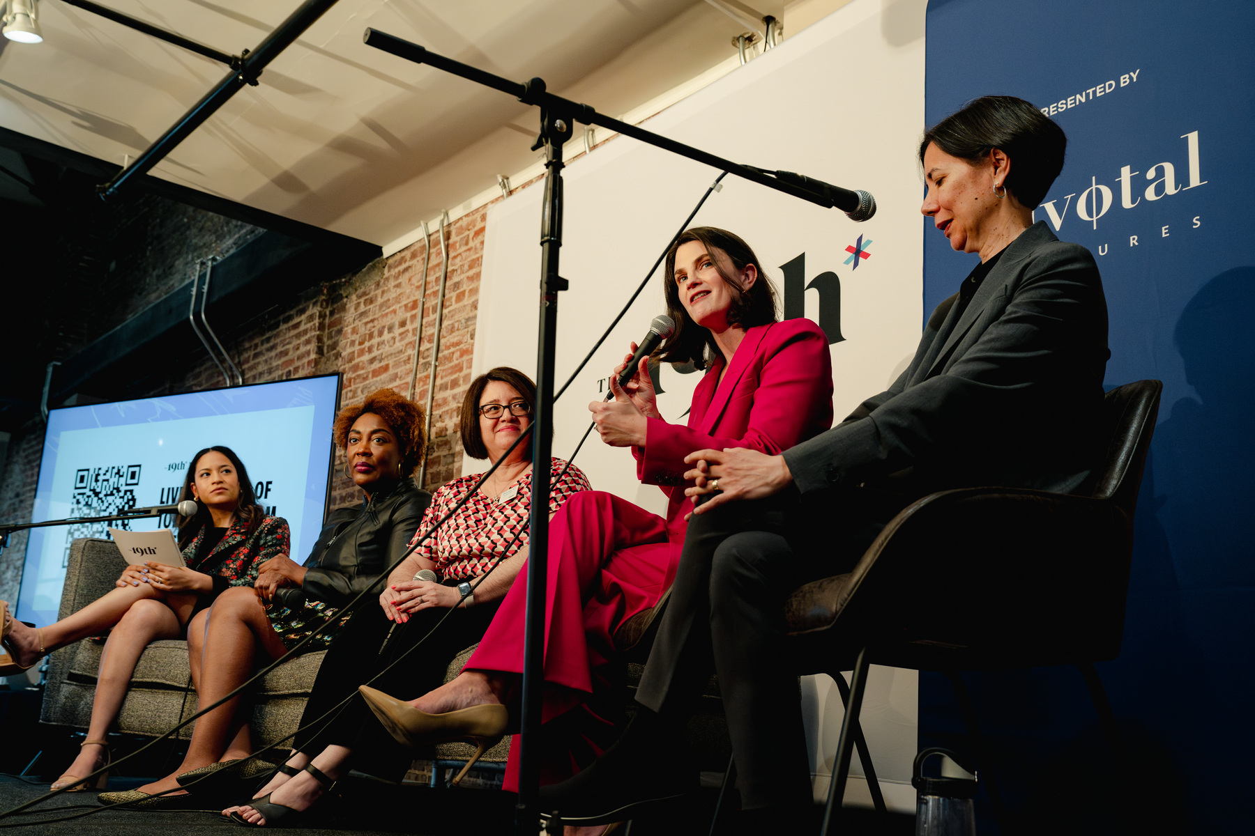 Women sit on a stage for a panel interview.