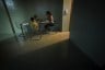 A woman sits with her son for dinner in their new, sparsely furnished apartment in New York.
