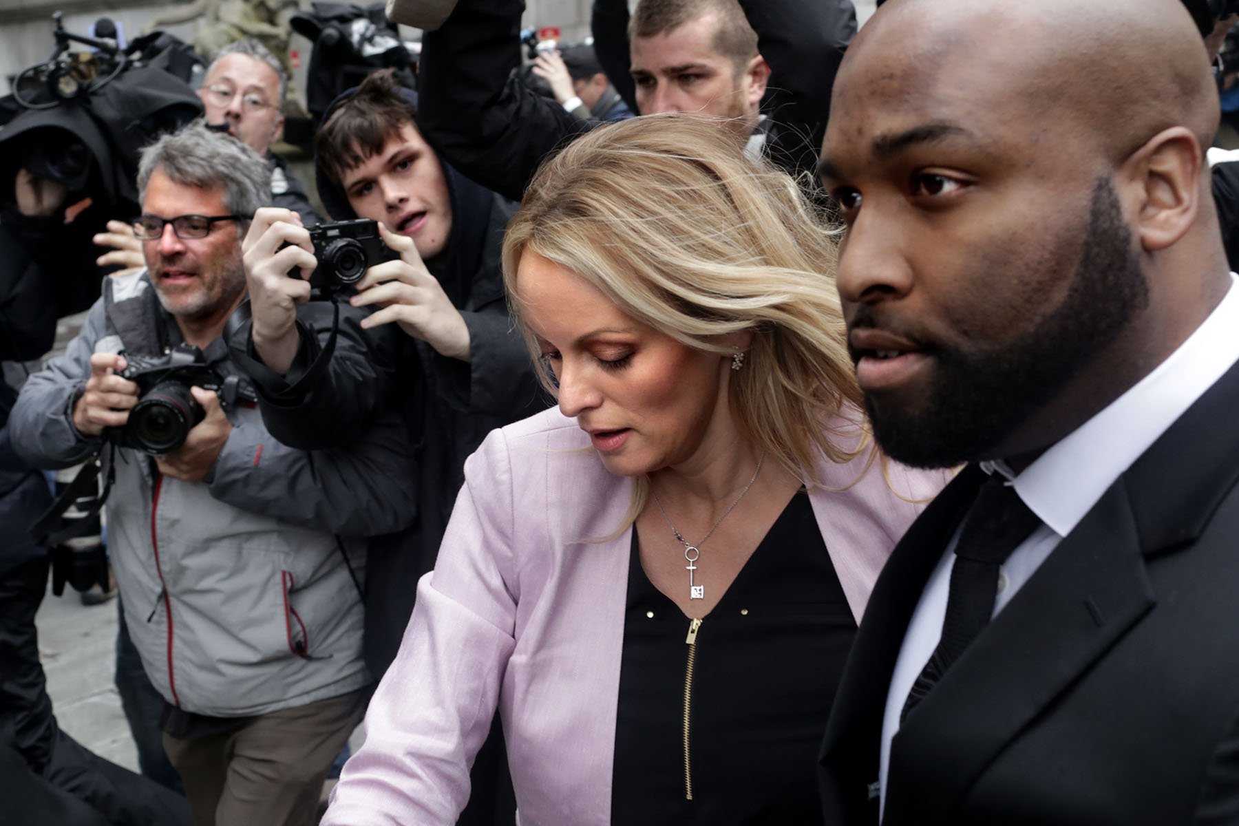 Photographers try to snap a shot of Stormy Daniels as a body guards tries to protect her as she arrives at the United States District Court Southern District of New York for a hearing.