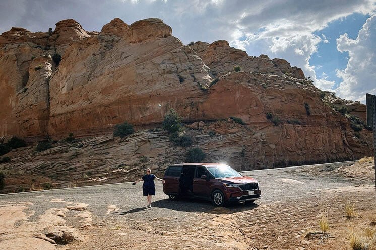 Drabinski stands next to a van in front of a large rocky formation.