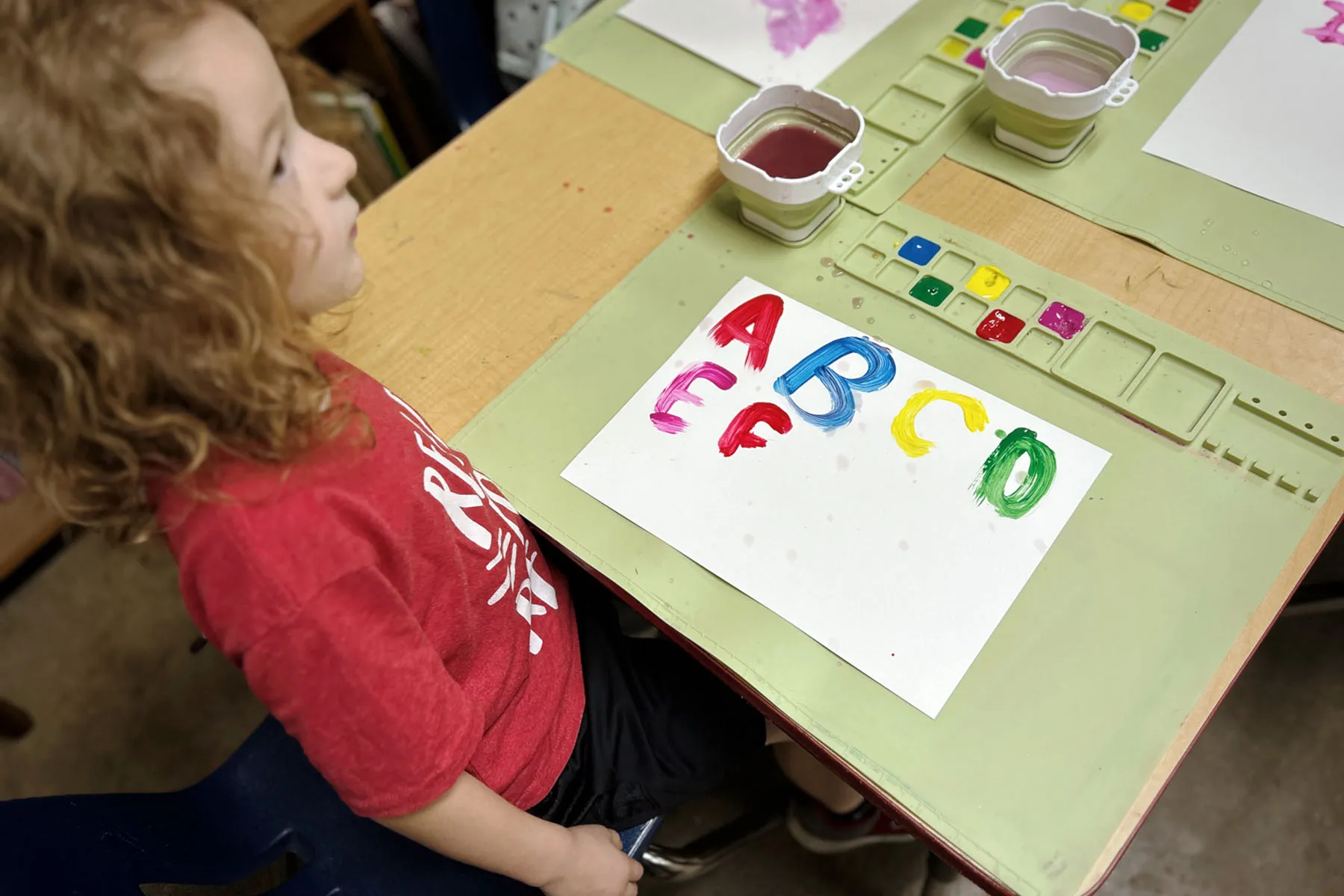 A child paints the ABCs at school.