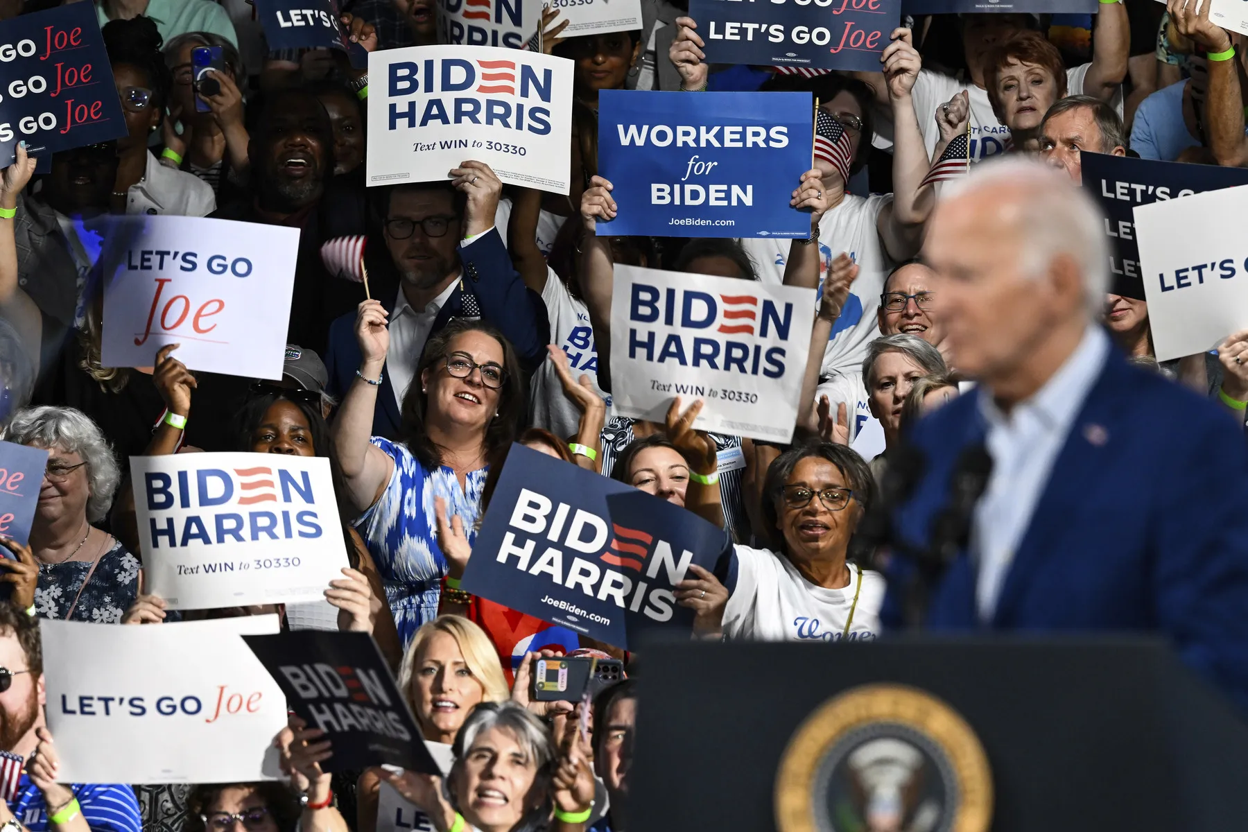 Supporters cheer as President Joe Biden speaks at a campaign rally.