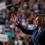 Kamala Harris smiles as she waves to supporters during a campaign rally at West Allis Central High School.