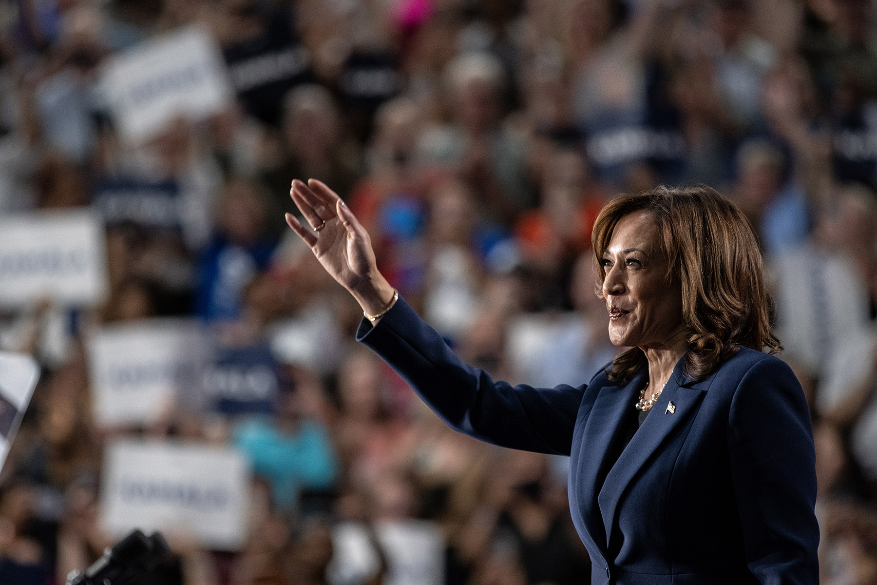 Kamala Harris smiles as she waves to supporters during a campaign rally at West Allis Central High School.