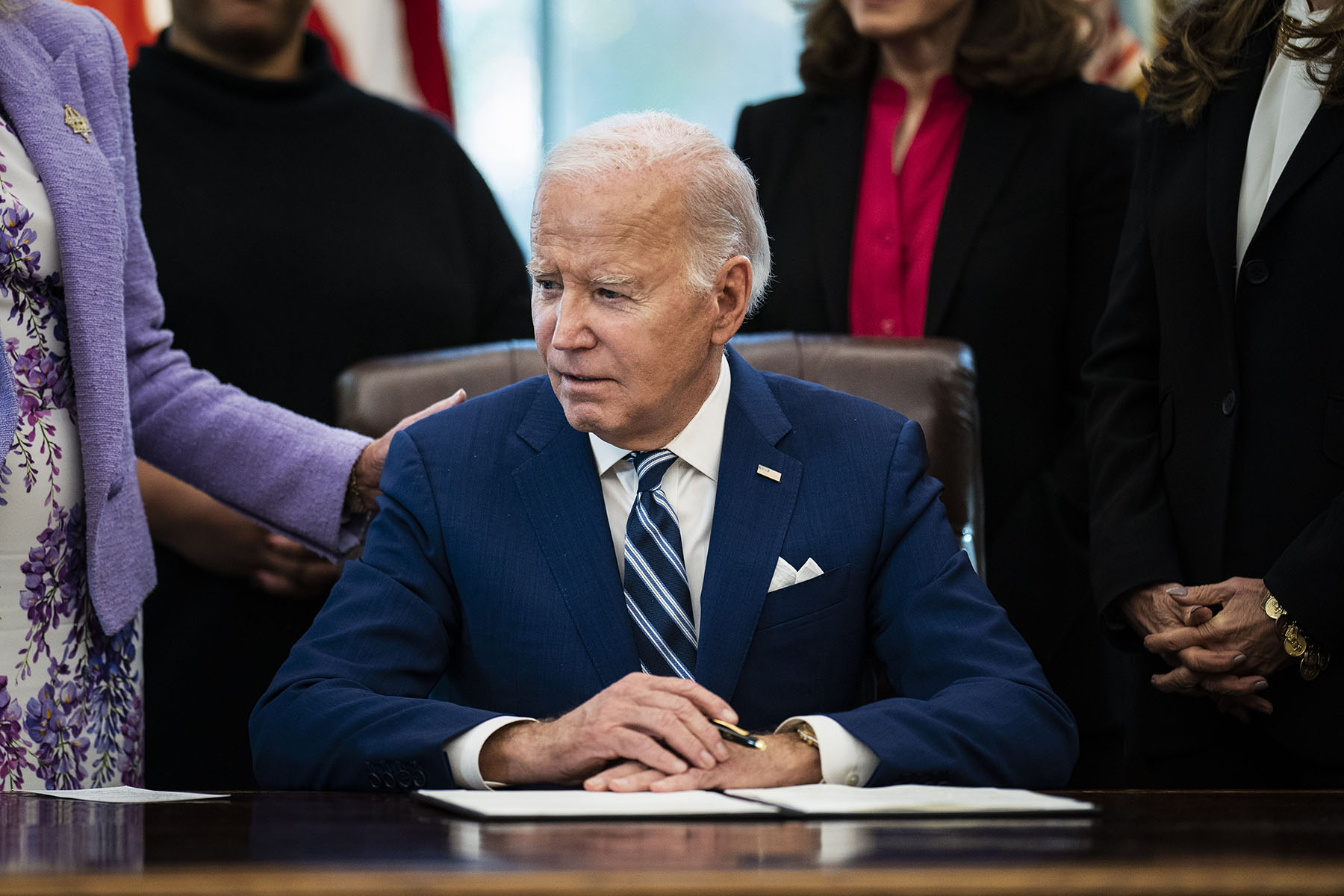 President Joe Biden signs a presidential memorandum in the Oval Office at the White House.