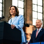 Vice President Kamala Harris speaks at a campaign event at Girard College in Philadelphia. President Biden stands behind her and smiles.