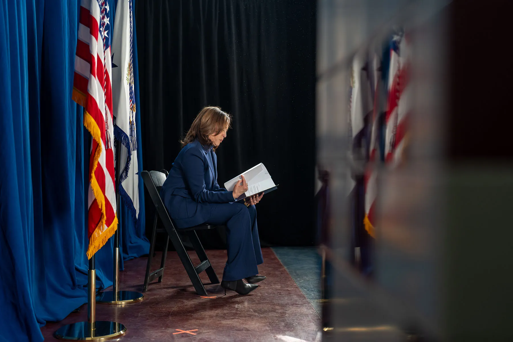 Vice President Kamala Harris reads notes backstage as she prepares to make remarks at an event.