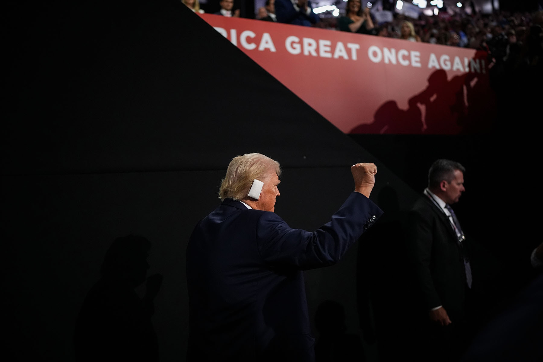 Donald Trump raises his fist as he arrives on the second day of the Republican National Convention with a bandaged ear.