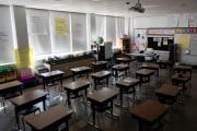 Desks are seen in an empty elementary school classroom.