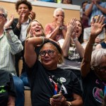 Group of Harris supporters reacting emotionally during a watch party for the 2024 presidential debate.