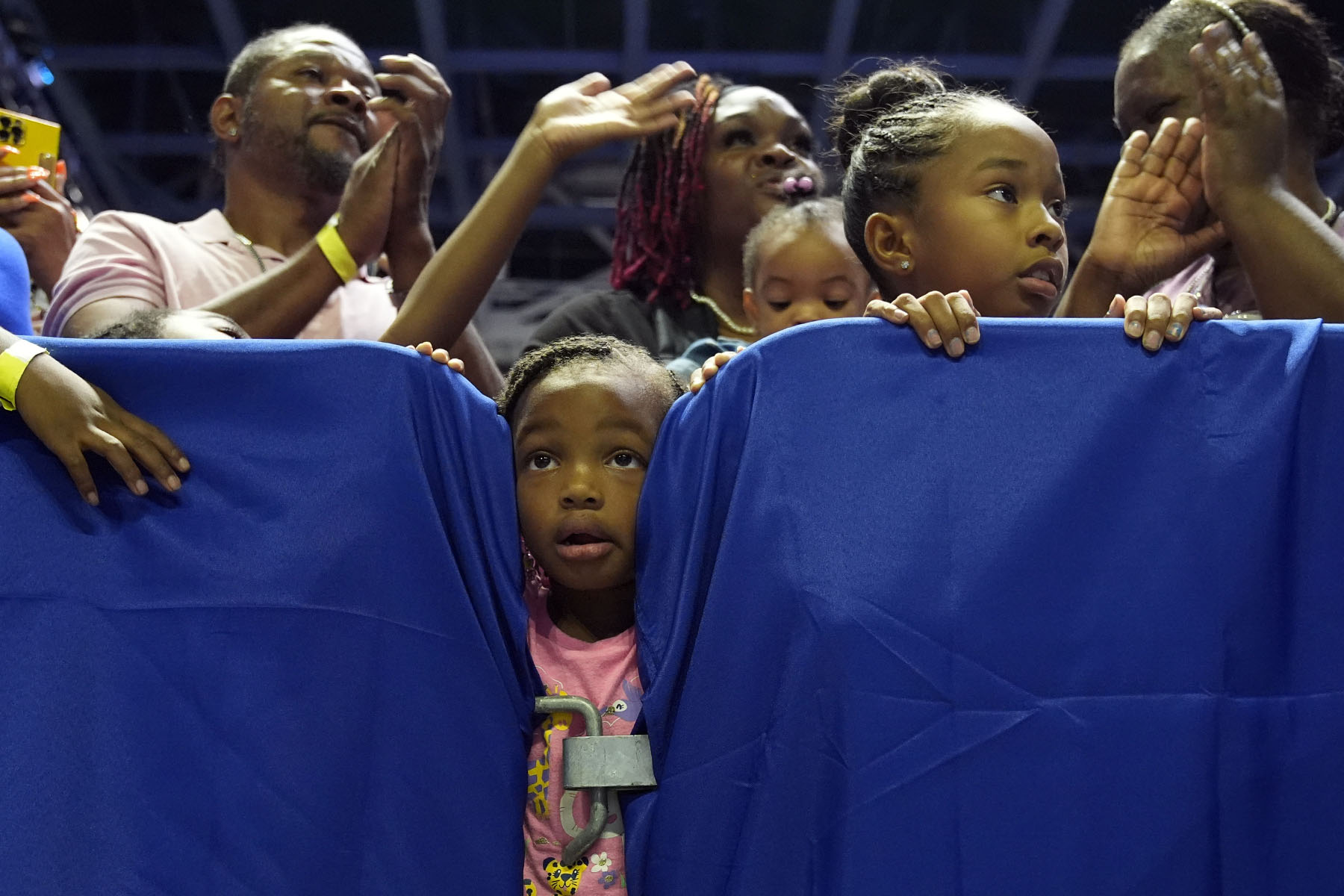 La gente, incluidos niños, escucha mientras la vicepresidenta Kamala Harris habla en un mitin de campaña en Savannah, Georgia.