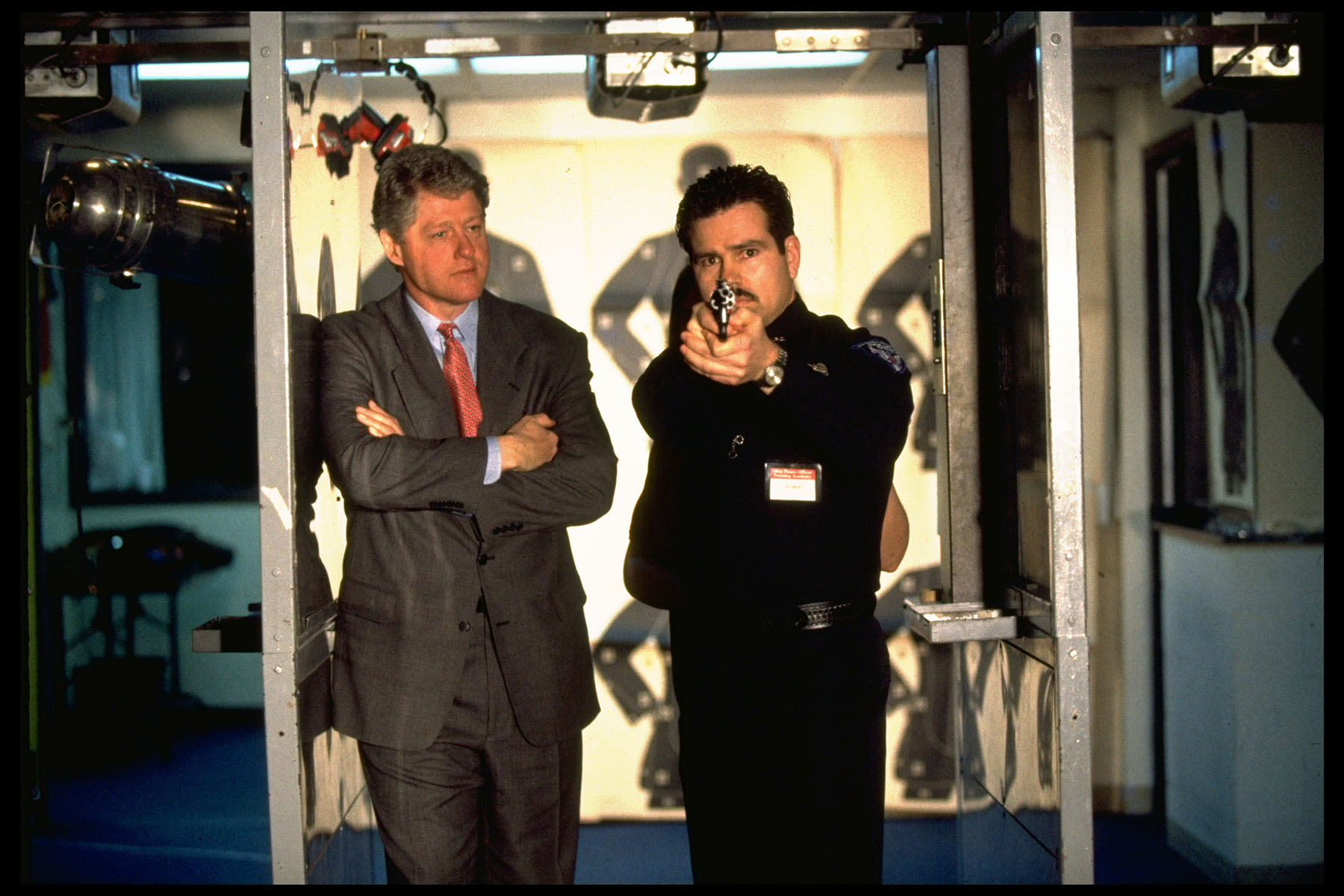 President Bill Clinton watches a student police officer aim his handgun in shooting practice at an Ohio police training facility.