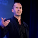 Corey DeAngelis speaks on stage at an event.