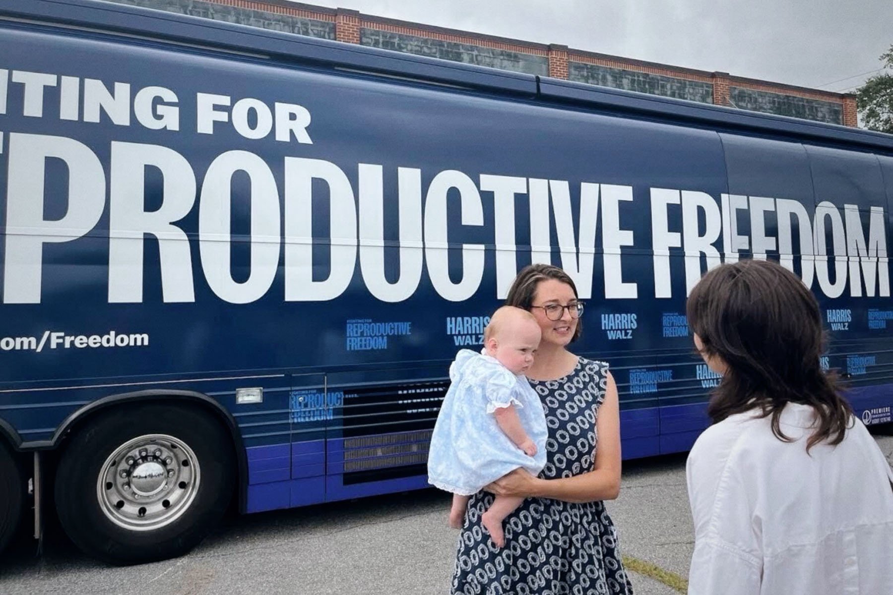 Callie Beale Harper, a Georgia mother, stands in front of the 'Fighting for Reproductive Freedom' campaign bus with her baby.