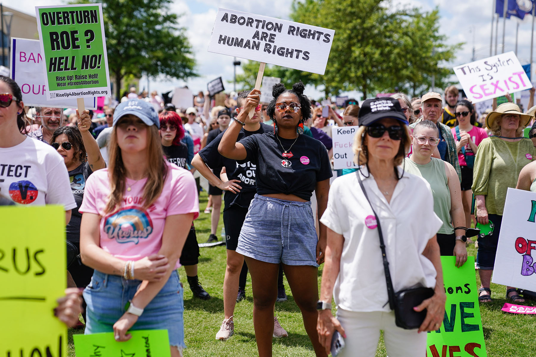 A group of protesters in Georgia holding signs supporting abortion rights. One woman holds a sign reading 'Abortion rights are human rights,' while others around her display messages opposing the overturning of Roe v. Wade.