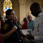 A Springfield police officer chats with parishioners after a service in support of the Haitian community at St. Raphael Catholic church in Springfield, Ohio.