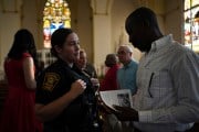 A Springfield police officer chats with parishioners after a service in support of the Haitian community at St. Raphael Catholic church in Springfield, Ohio.