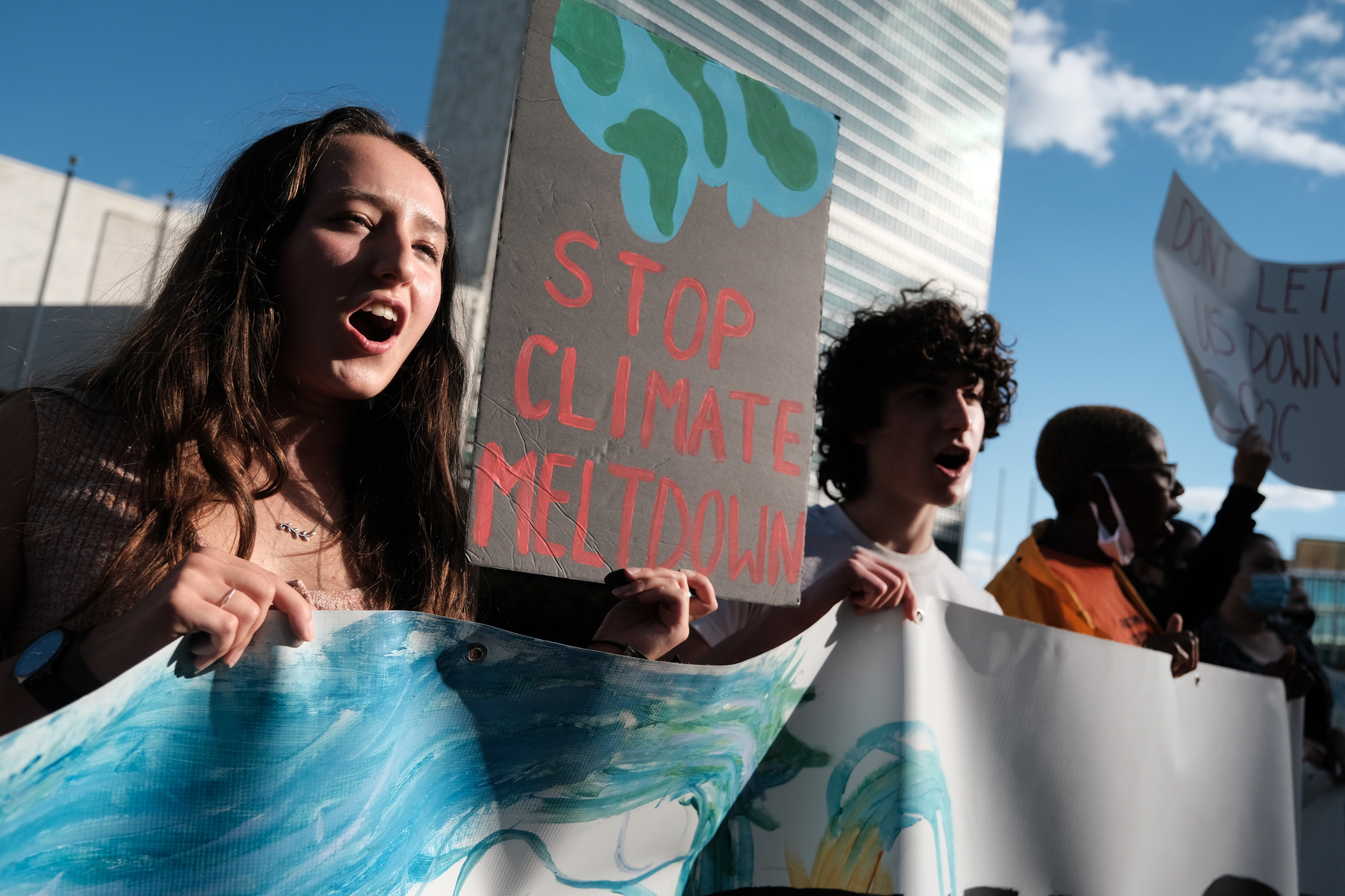 A group of students hold signs and take part in a protest in support of the climate.