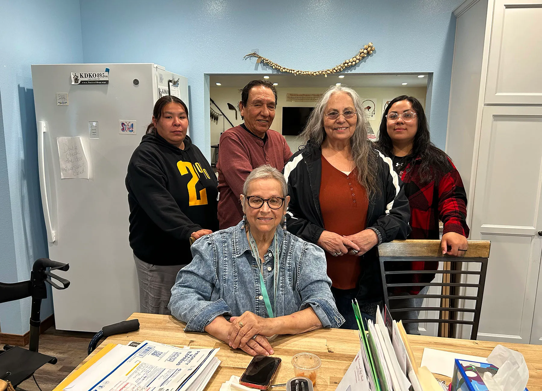 Charon Asetoyer poses for a portrait surrounded by her staff.