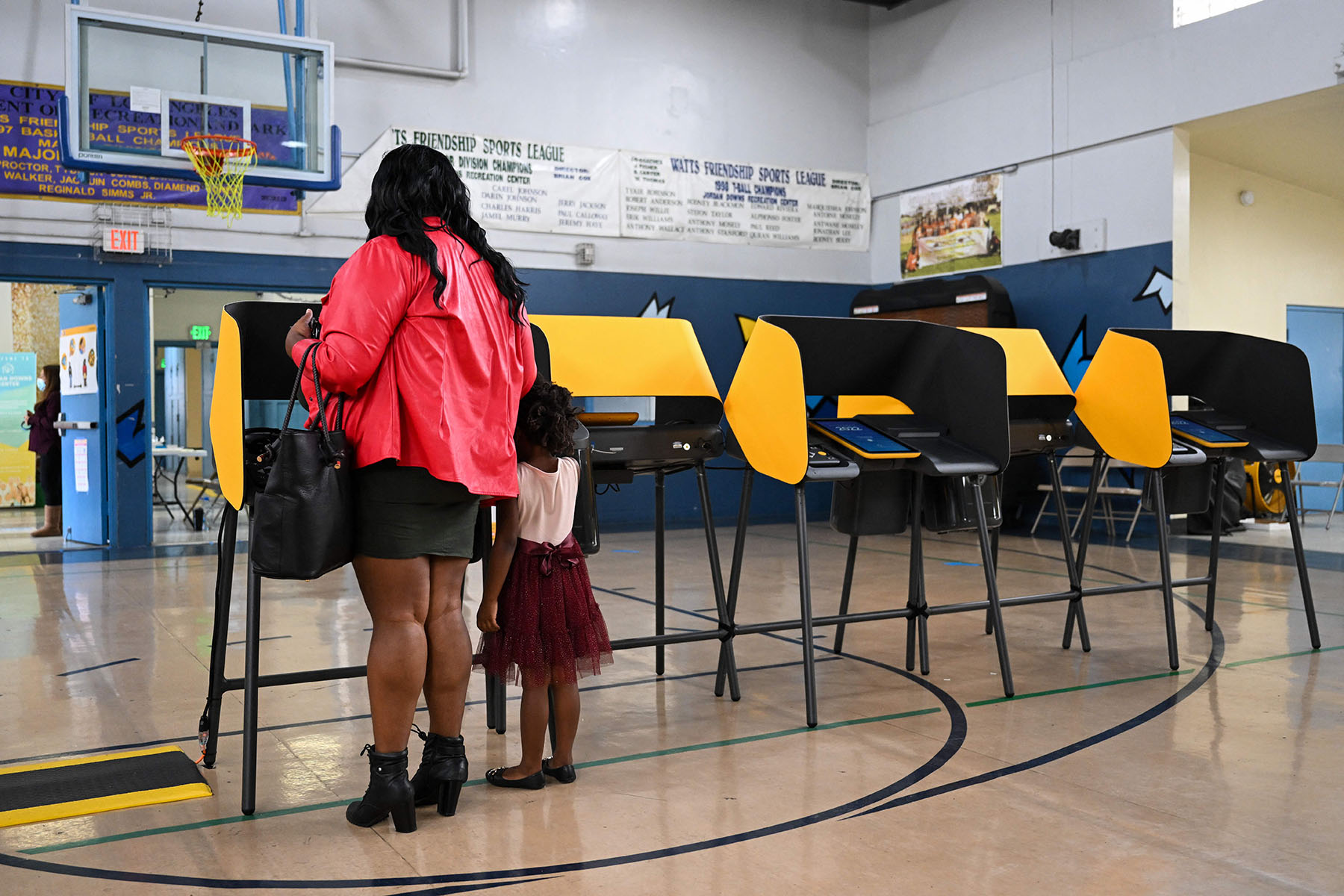 A person accompanied by a young child votes in midterm elections at the Jordan Downs Recreation Center in Los Angeles.