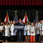 Florida Governor Ron DeSantis speaks onstage surrounded by people in white coats during an event with Florida Physicians Against Amendment 4 in Coral Gables, Florida.