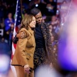 Vice President Kamala Harris and Former first lady Michelle Obama hug on stage at a rally in Kalamazoo, Michigan.