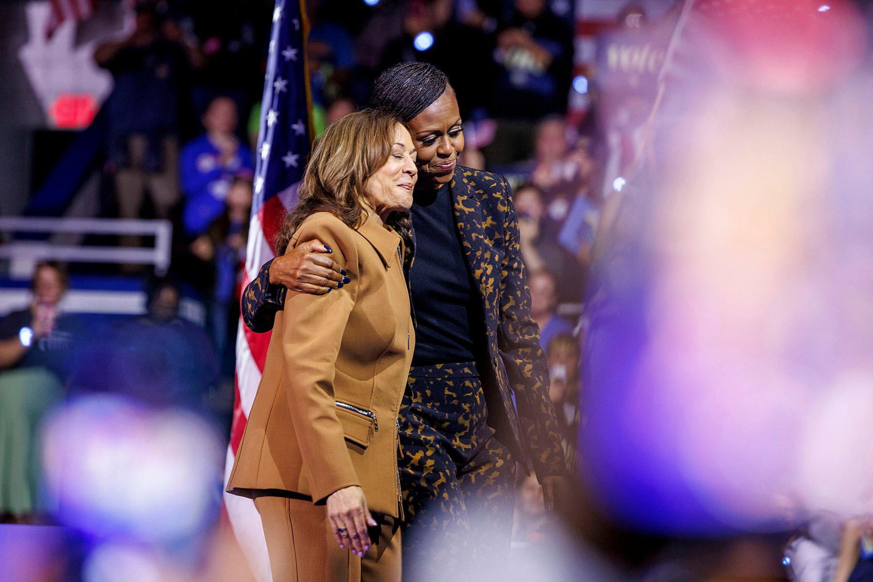 Vice President Kamala Harris and Former first lady Michelle Obama hug on stage at a rally in Kalamazoo, Michigan.